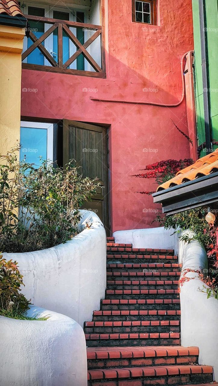 Mykonos Streets with pastel pink ,green walls and white stairs with beautiful garden across 😍😍😍