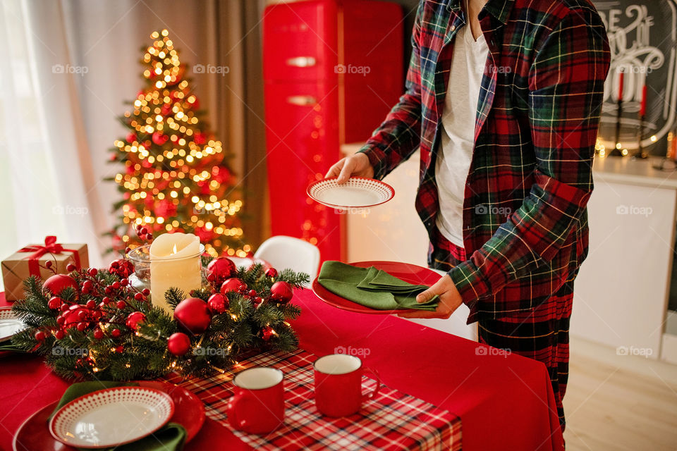 man sets a beautiful decorated winter table for a festive dinner.  Merry Christmas and Happy New Year.