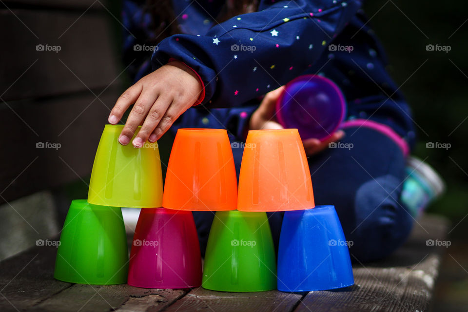 Little child is playing with colorful cups from ikea