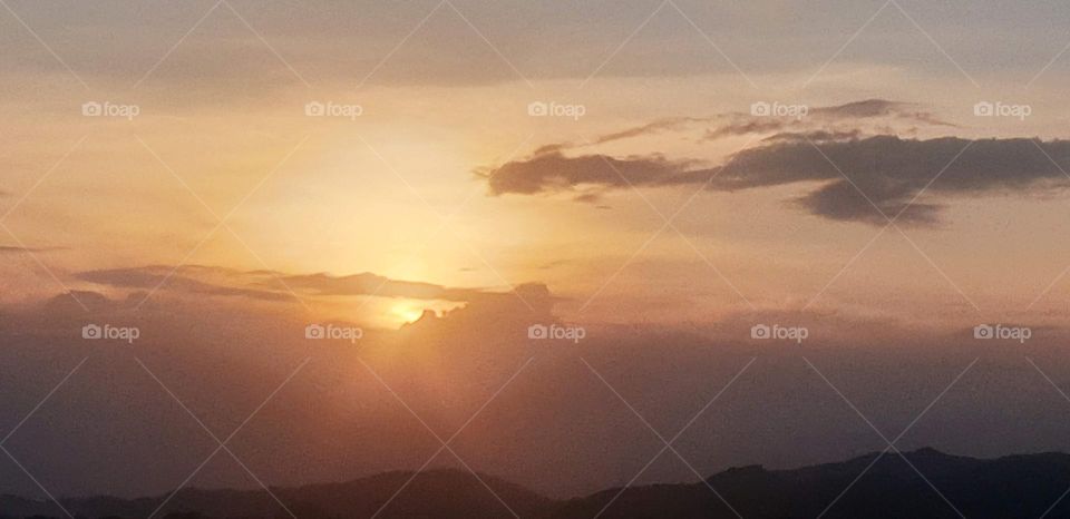 beautiful sunset with clouds covering the beautiful landscape, sun shine