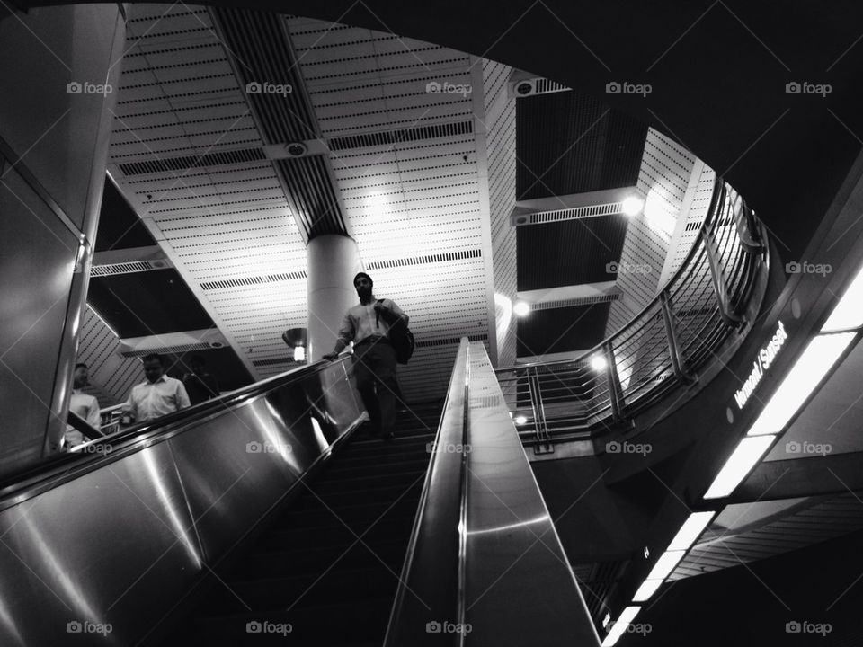 Man Walking Down Escalator