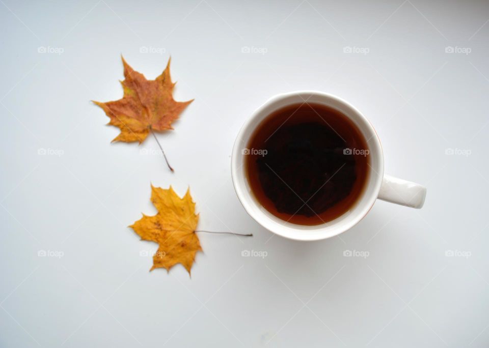 lifestyle cup of tea and yellow autumn leaves top view