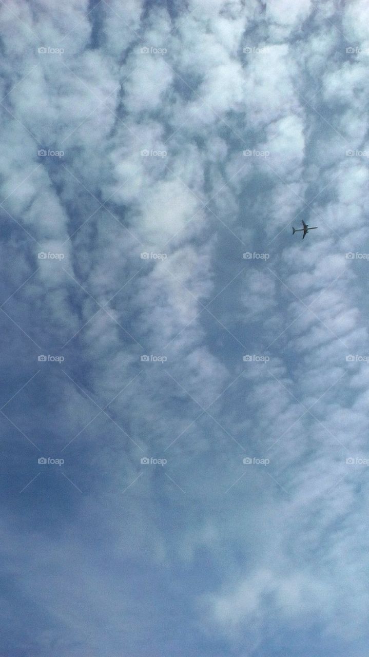 Blue scenic beautiful sky with many
puffy clouds and airplane in sunny day
of march
