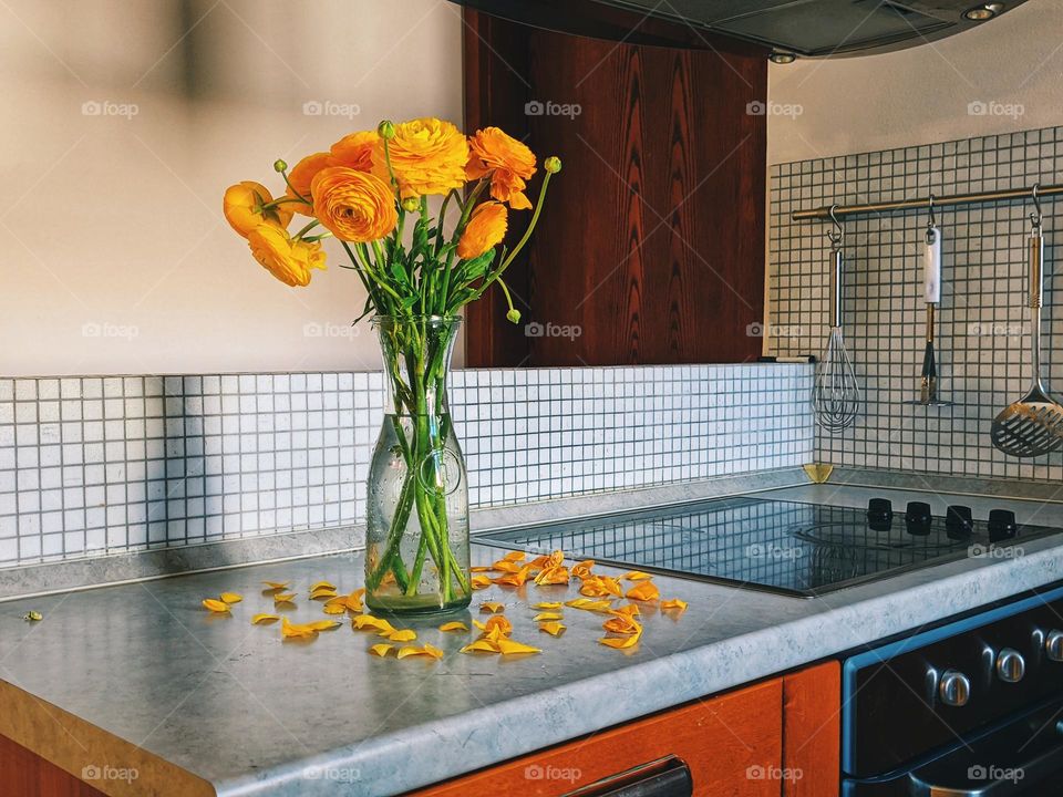 Top view of yellow blooming flowers in a vase at a cozy home. Ranunculus