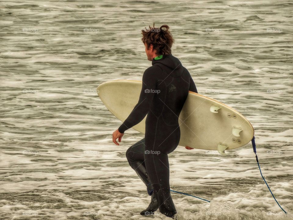 Surfer entering the cold waters of Pacifica, Northern California
