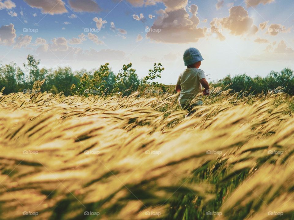 A child enjoys a hike in the middle of a field