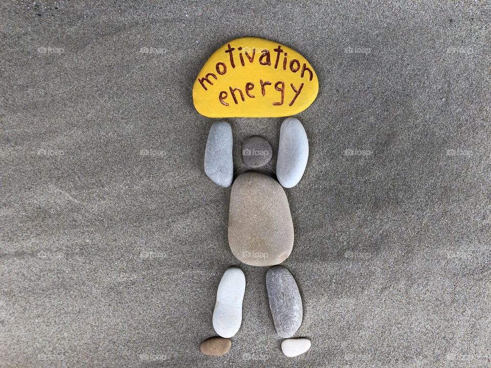 Motivation and energy message with a stones composition over the sand