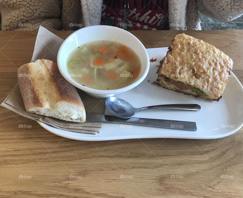 Chicken noodle soup with carrots and vegetable chicken and avocado tomato sandwich and a whole green slice of bread for Lunch at panera bread .