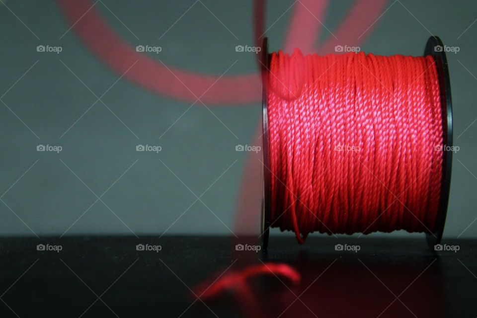 Close-up of a red mason's cord coiled on a spool