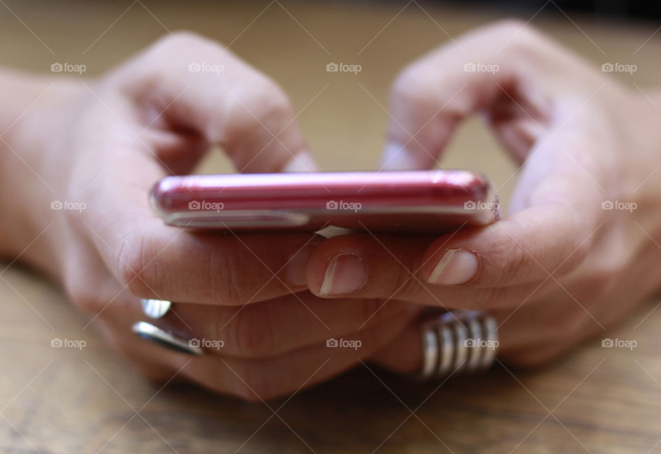 Using mobile phone, hands holding a phone, close up