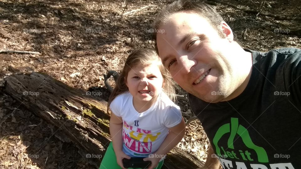 A father and daughter on a hike on the woods