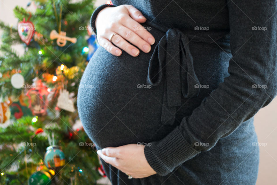 Pregnant woman touching her belly with hands