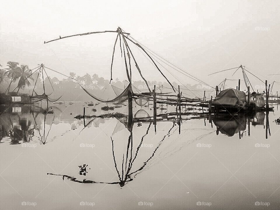 Misty, tranquil & surreal vision of the ancient fishing nets of Kerala, India by the river...