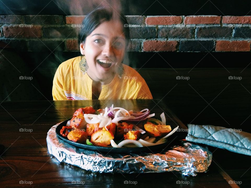 Teenage girl sitting in restaurant with delicious food