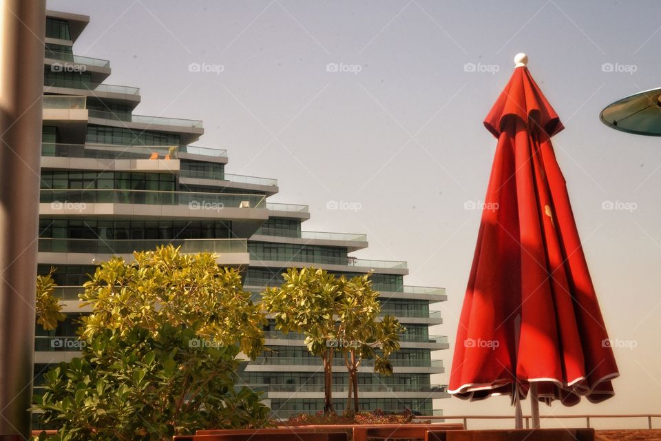 Representational photography of urban landscape with special attention added to the red umbrella. Still and immovable 