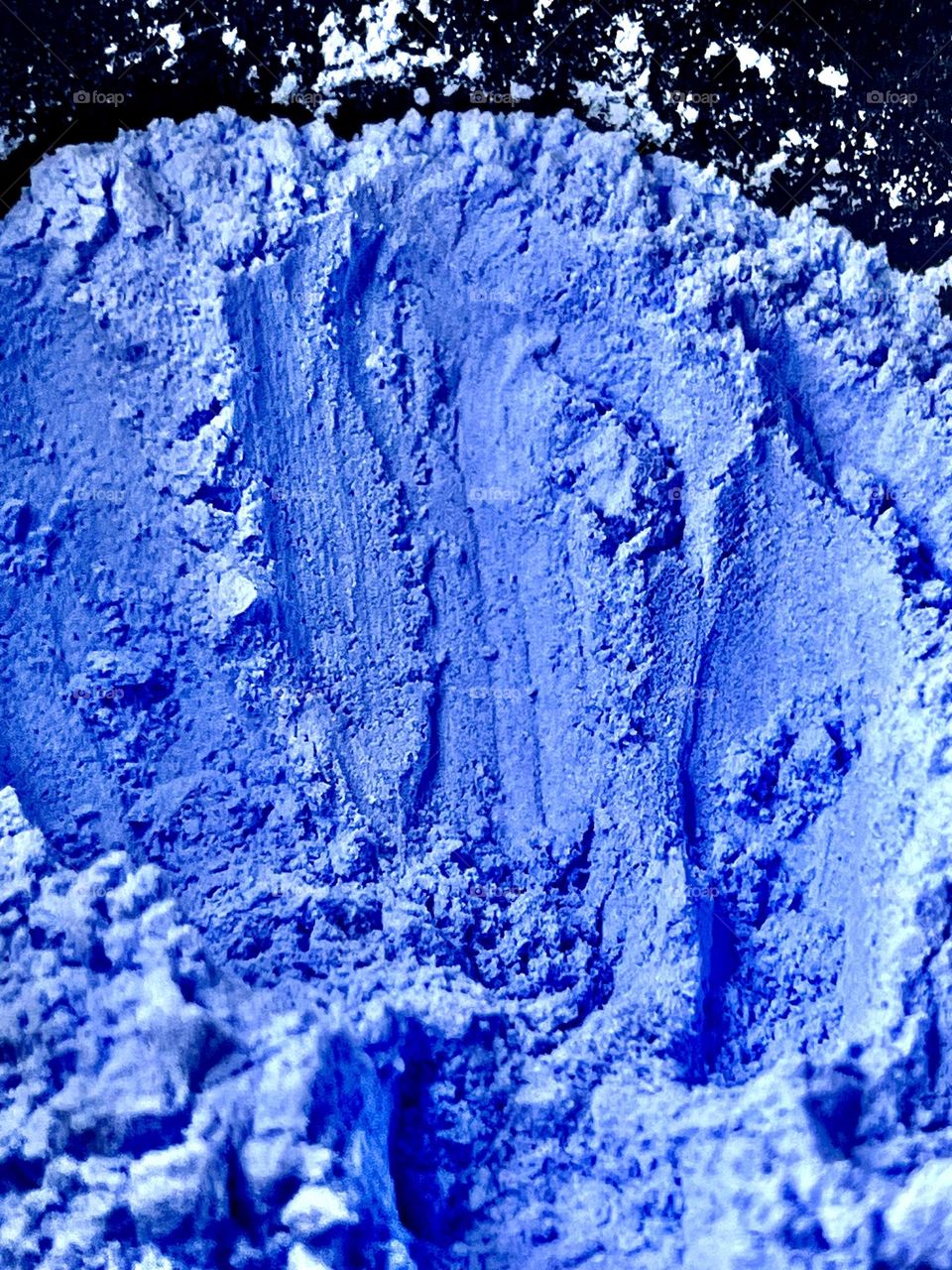 Blue powder close-up shot against a dark background