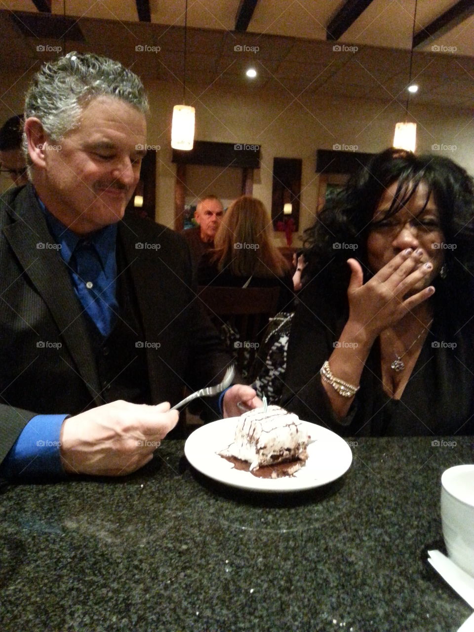 Man and woman sitting in restaurant with ice cream