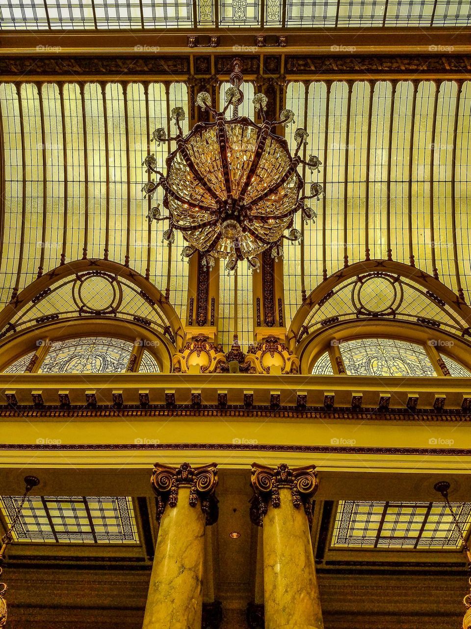 Inside looking up at the palace hotel in San Francisco, beautiful Victorian style with intricate stained glass and crystal chandeliers 