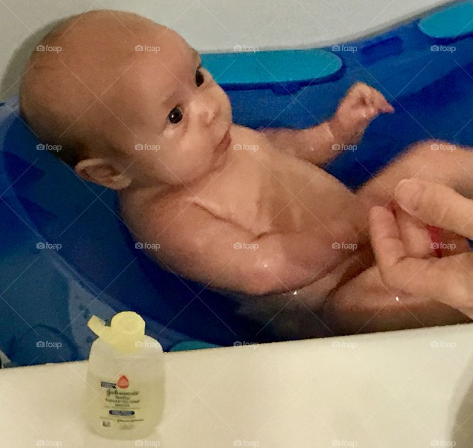 2 1/2 month old getting her bath and staring up lovingly at her mommy.  Johnson’s baby bath soap in foreground. 