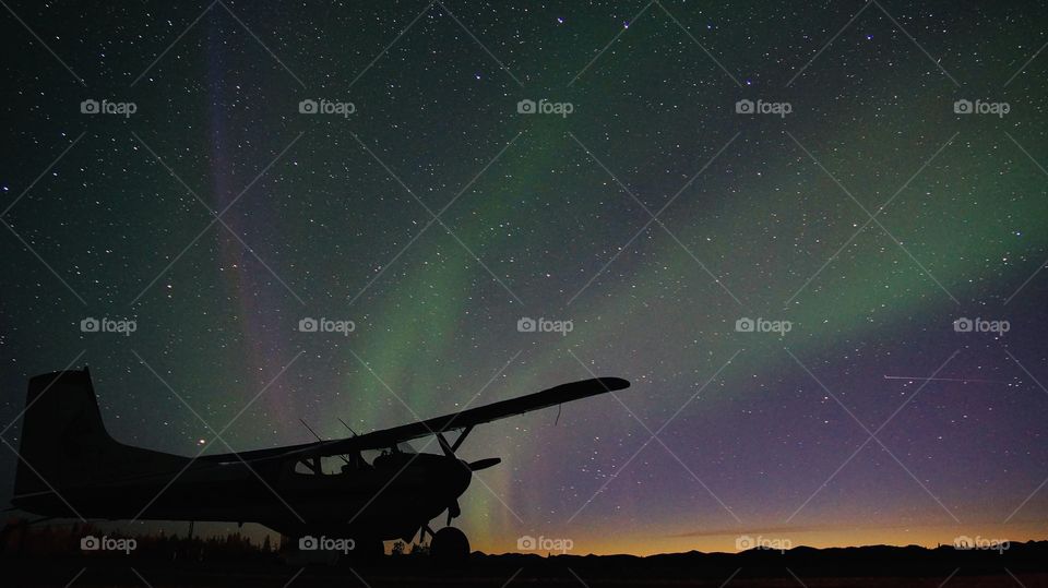 Airplane under northern lights