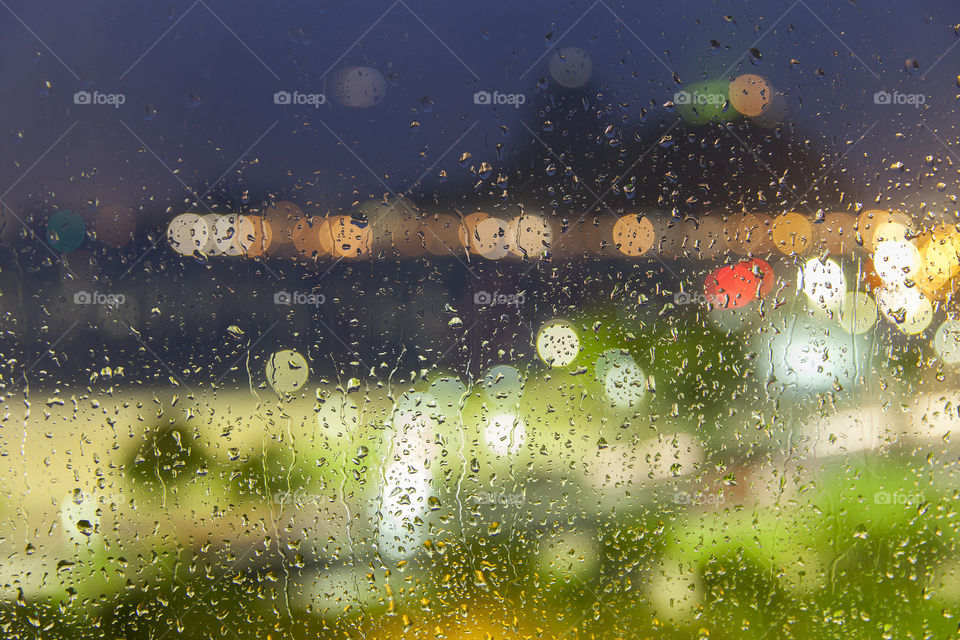 Drops of rain on a window with lights out of focus