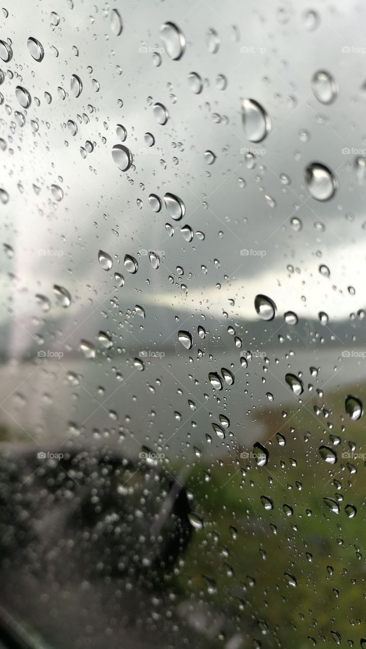 Raindrops on a Car Window and Blurry Lake Background