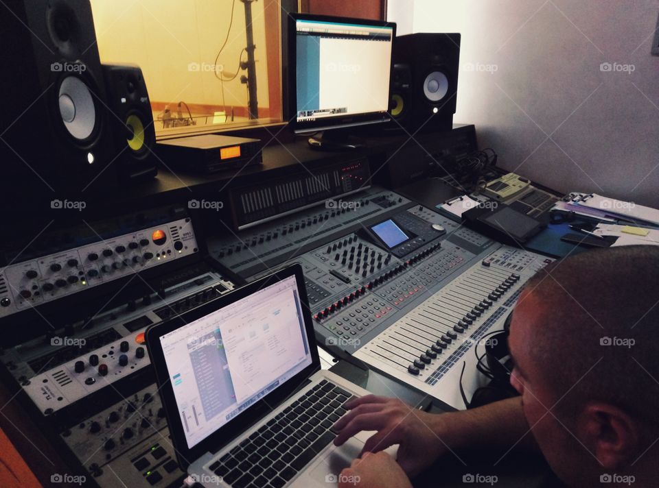 Man working in a recording studio. Audio mixing board.
