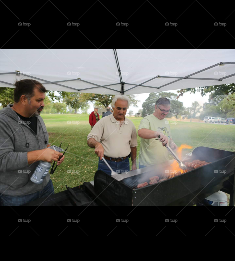 Group of men preparing food on barbecue