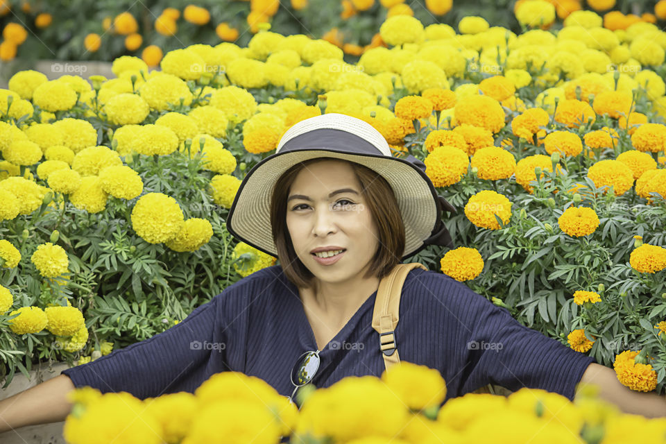 Woman in Yellow Marigold flowers garden or Tagetes erecta in garden