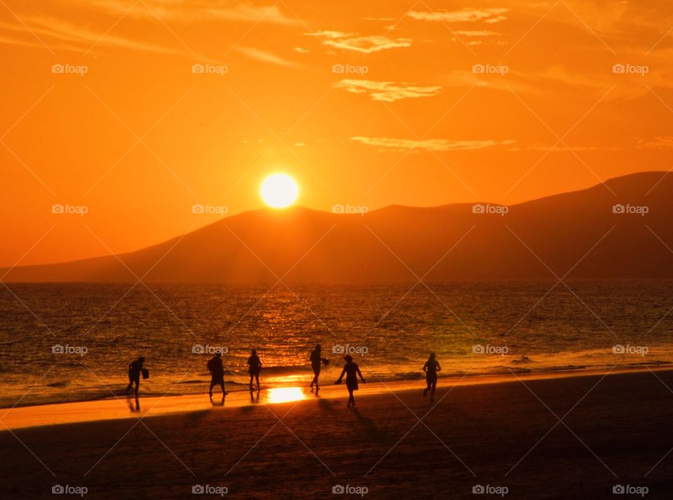 People at the beach during sunset 
