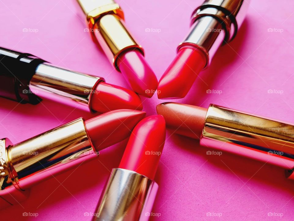 detail of colorful lipsticks on pink background