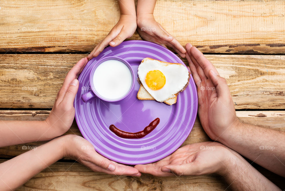 High angle view of peopl's hand with breakfast in plate