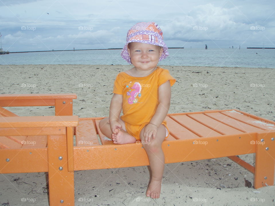 Portrait of cute baby girl sitting deck chair