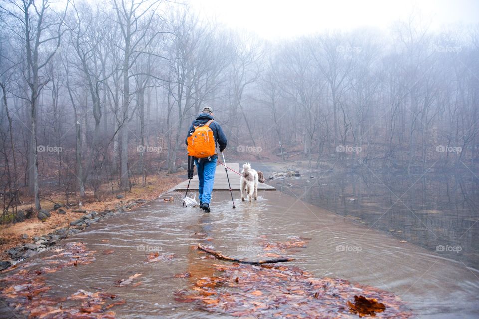 A man takes an early hike with his best friend 