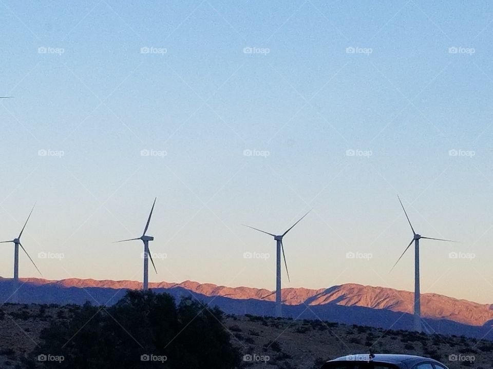 Wind turbines in a row against a desert backdrop