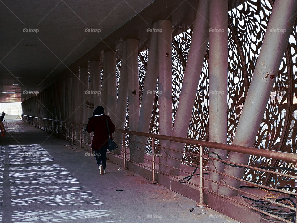 A woman walk on the bridge.