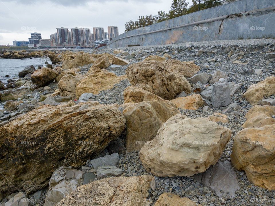 Pebble beach. A part of the city and the embankment is visible.