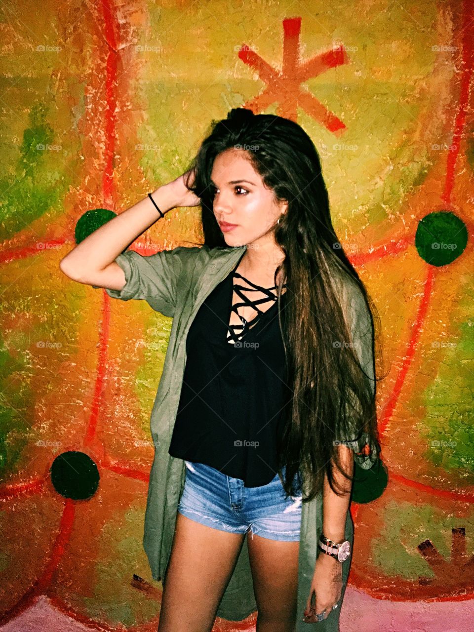 Woman standing near painted wall