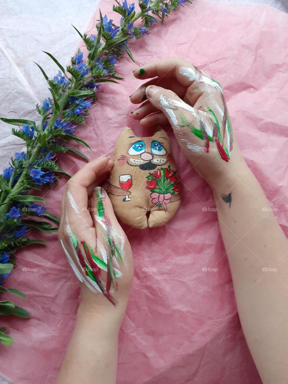 Handmade toy cat on a pastel pink background