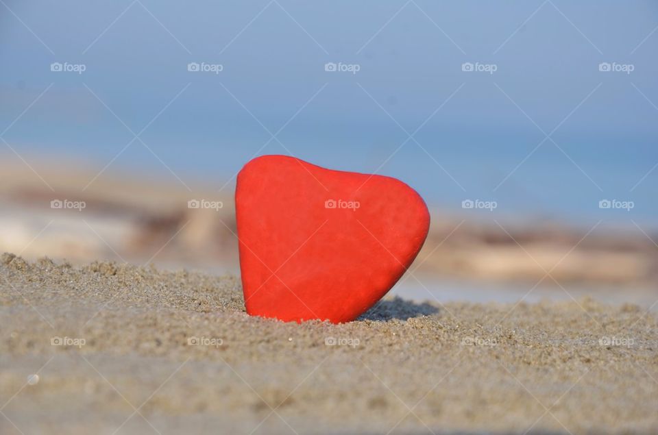 Lonely red hearth on the beach