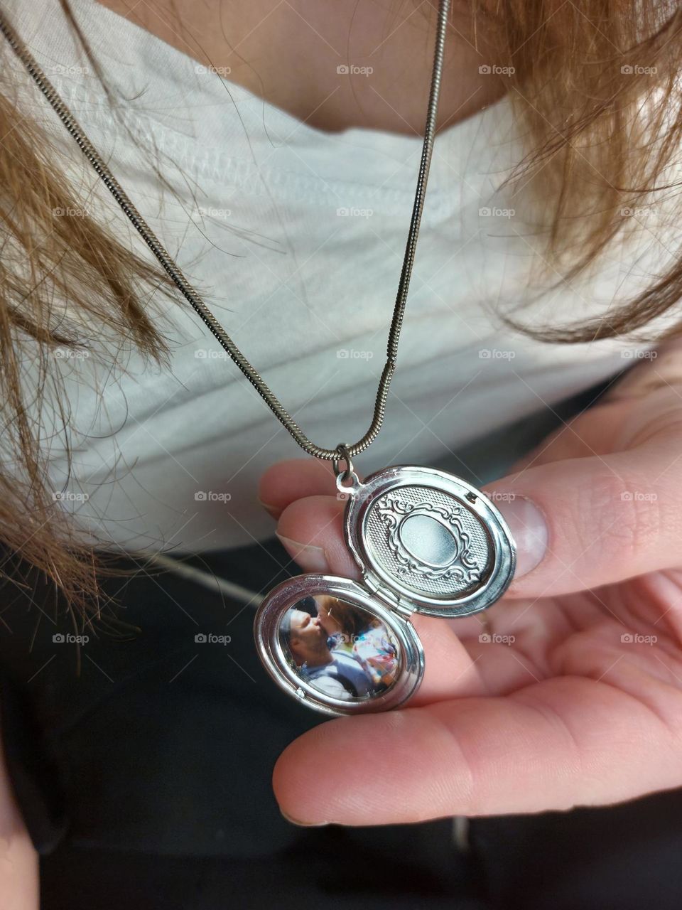 silver locket with picture inside.
