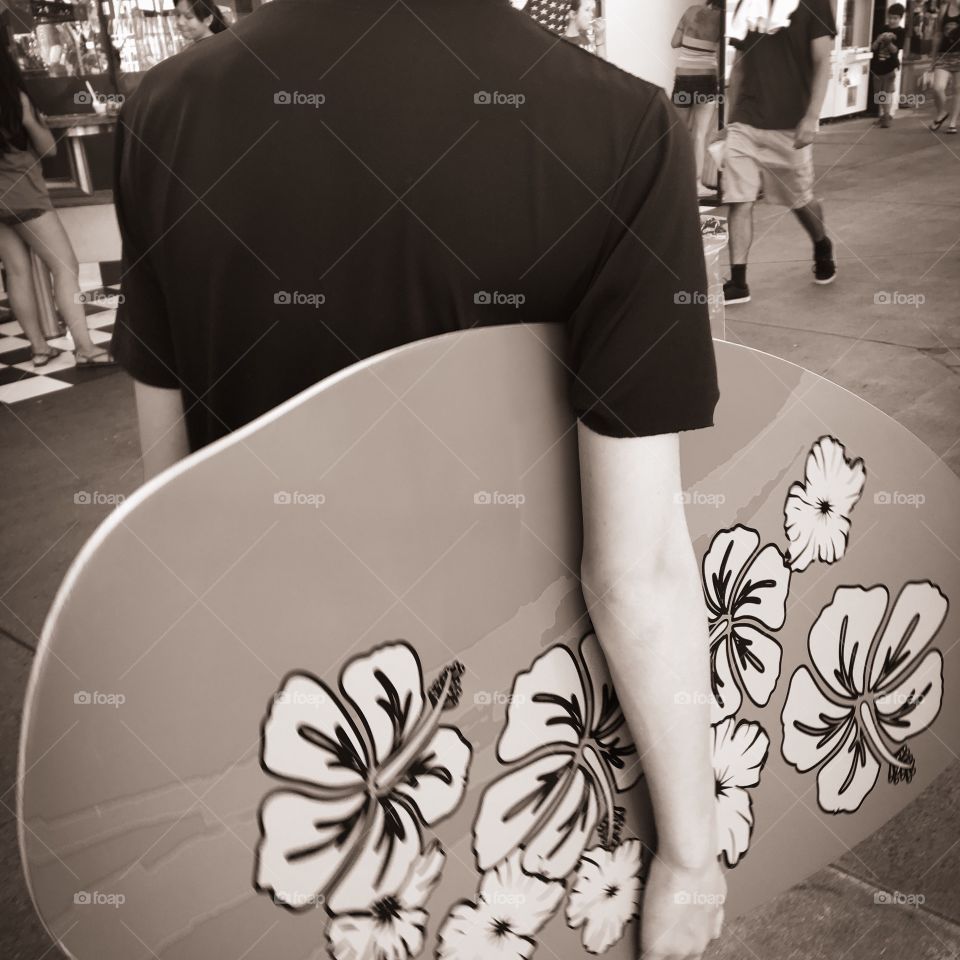 Teenager and his skimboard on the boardwalk 