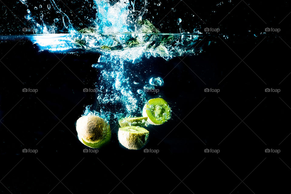 fresh kiwi splashing in cold water