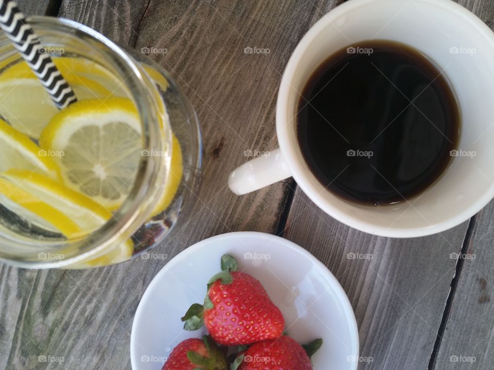 Black coffee with lemon water and strawberries