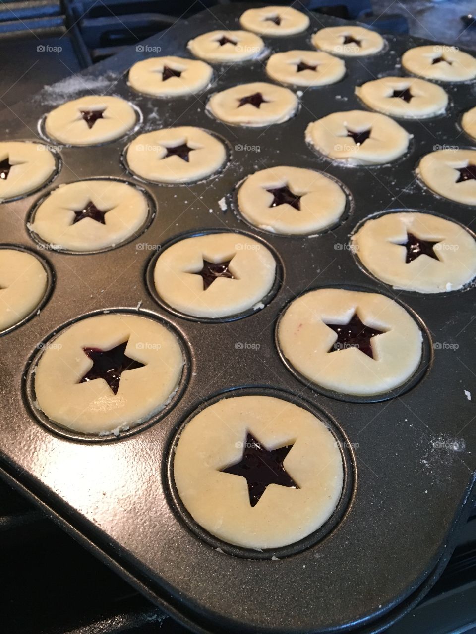 Mini Blueberry Pies are ready to go in the oven! Topped star shaped cut-outs they are reminiscent of barn stars. 