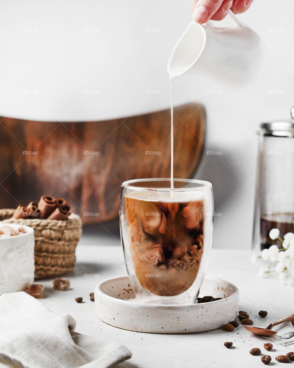 milk pouring in a glass of coffee