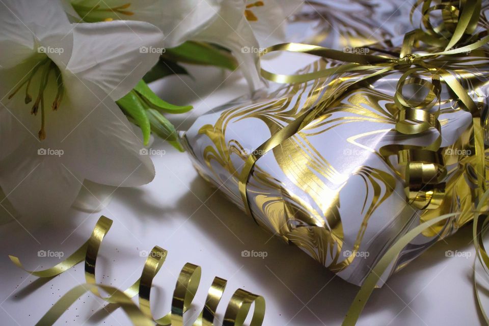 Gifting season in all it's beauty. Gold trimmings and swirled wrapping paper concealing the present to be given at Christmas.