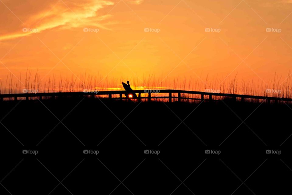 Surfer walking towards beach 
