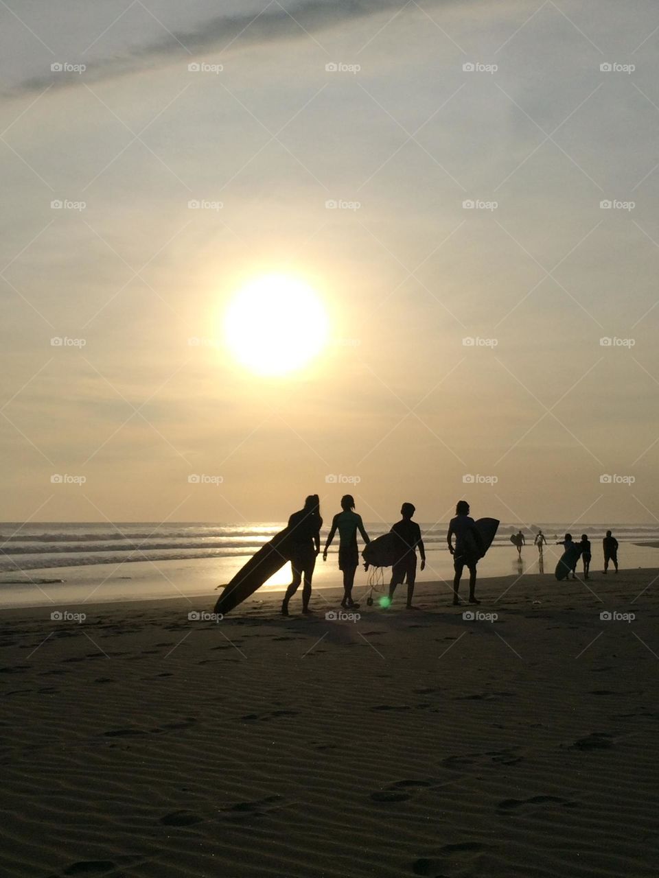 Surfing culture and evening promenade along Seminyak area of Bali coast. 