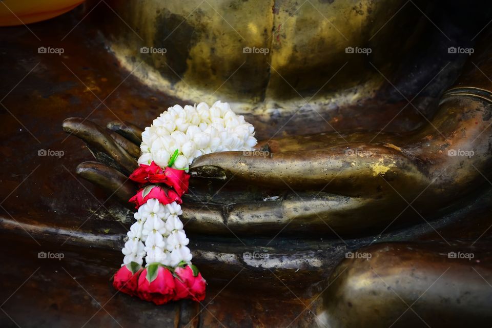 White flowers garland on the Buddha in the Thai temple
